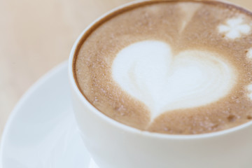 heart symbol on latte coffee cup on table