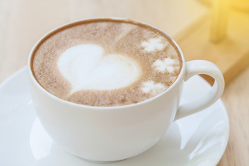 heart symbol on latte coffee cup on table