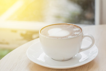heart symbol on latte coffee cup on table