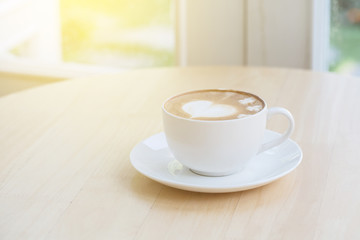 heart symbol on latte coffee cup on table