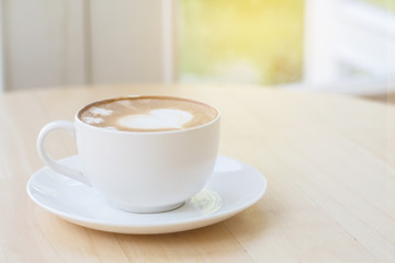 heart symbol on latte coffee cup on table