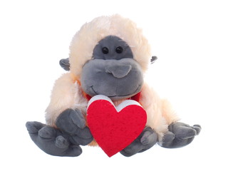 monkey suffed toy holding red heart symbol on white background