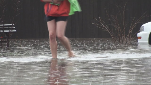 Man and woman walks through flooded neighborhood area. At that time Flood stage in this area was 9.6ft, major flooding stage is 9.0ft.