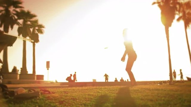 Hula hoop performance of women filmed in slow motion with lens flare near Venice Beach, California