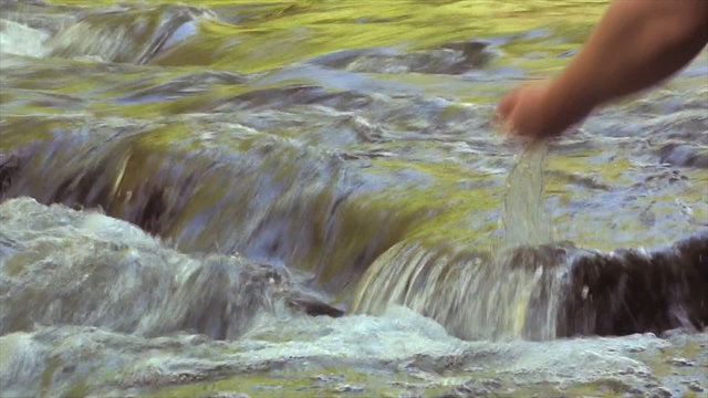 Man drinks water from the rushing stream 2.