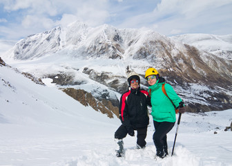 Fototapeta na wymiar Two tourists go to the mountains in winter