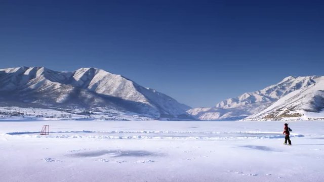 Someone stepping onto a frozen pond.