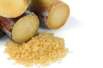Sugarcane and brown sugar on white background.  Selective focus.