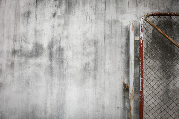 cement wall background with rusty iron chain wire fence