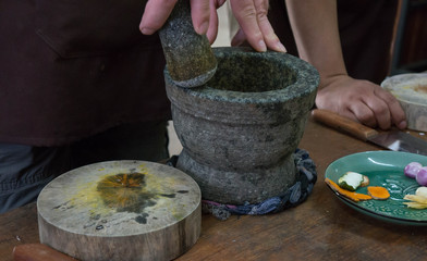 Person resting a pestle on an empty mortar