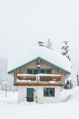 a house covered with thick snow on snowy day.