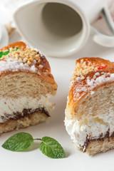 Cream cake with a cup of coffee and jar