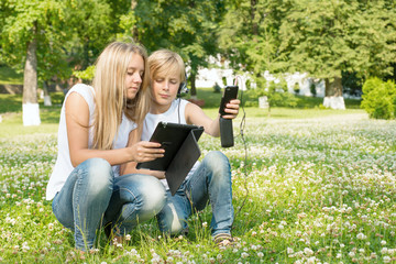 Naklejka na ściany i meble Boy and a girl with a digital tablet and phone