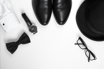 Men's accessories men's shoes, watches, glasses, bow tie, sleeve shirt and hat/Black and white minimalistic composition on a white background. Classic men's accessories. Top view - obrazy, fototapety, plakaty