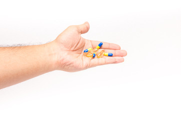 Men hand holding pile of yellow blue tablets
