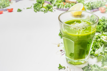 Green smoothie drink  in glass with ingredients on white wooden background, side view. Healthy food and detox  nutrition concept.