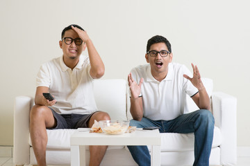 Men watching football match on tv at home