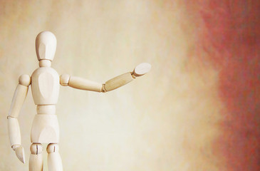 Wooden puppet points aside with its hand. Conceptual image about presentation