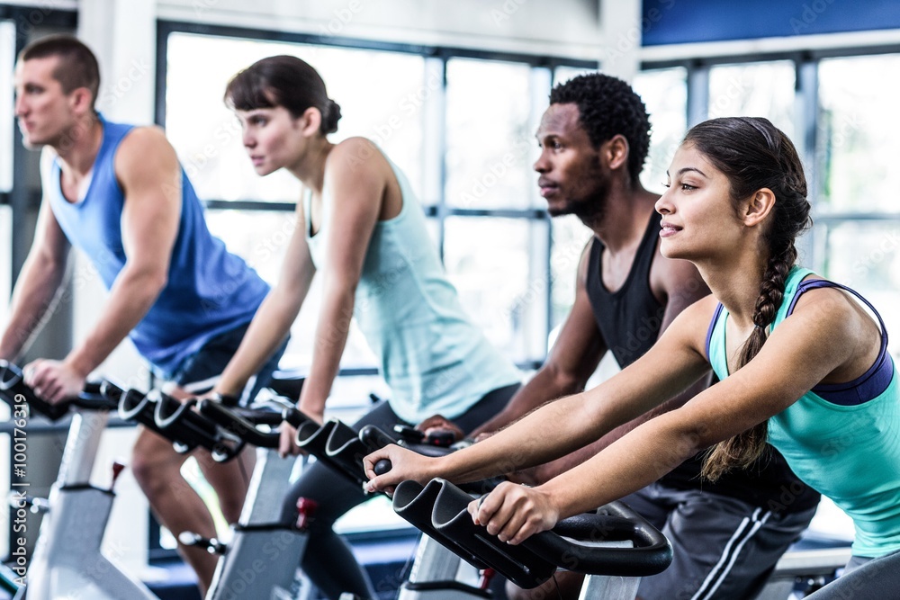 Wall mural Fit people working out at spinning class