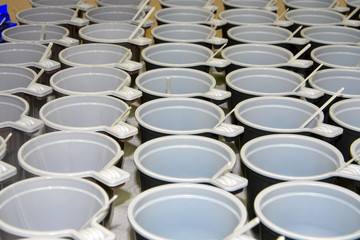 Background of plastic tea cups with spoons