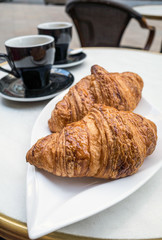 Breakfast with coffee and croissants on table