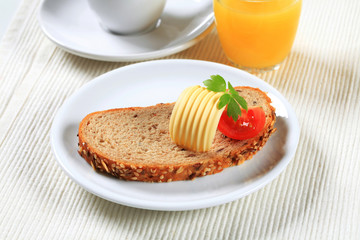 Bread with butter, cup of tea and orange juice
