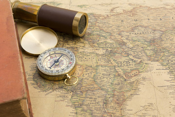 Fototapeta na wymiar Old book and old spyglass and old compass on vintage map world discovery concept