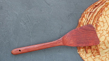 Crêpe sur fond en ardoise avec spatule en bois...carte, menu