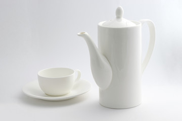 A white coffee pot and a cup