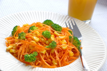 carrot spaghetti with fresh pieces of broccoli, corns and juice