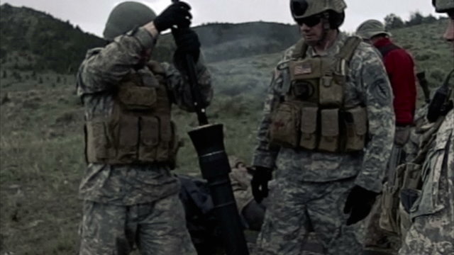 Slow motion clip of mortar team cleaning the mortar launcher.