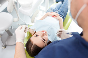Obraz na płótnie Canvas Experienced young dental doctor is examining female teeth