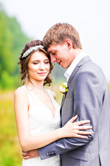 Stylish beautiful happy bride and groom in the field