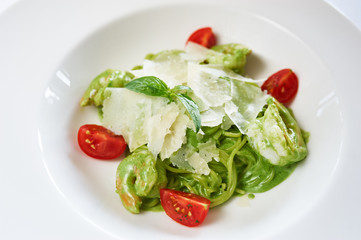 Spaghetti with spinach and shrimp on white plate studio shot