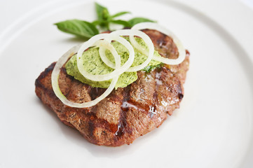 Beef tenderloin with herb butter on white plate studio shot