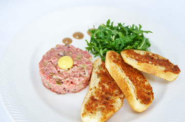 Tartare of veal on white plate studio shot