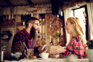 Lovely hipster couple enjoying sharing presents. Shallow depth of field.