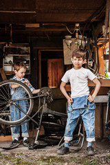 Obraz na płótnie Canvas Children mechanics, bicycle repair