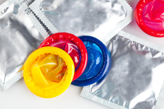 Couple of Colorful condoms with packaging, isolated on white