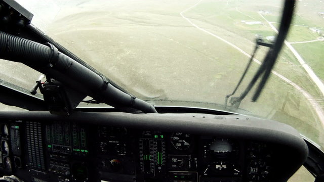 Black Hawk copilot looking down, flying w/ windshield wipers.
