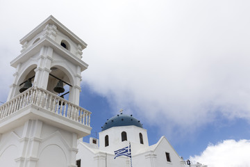 Traditional Greek white church arch with cross and bells in Sant