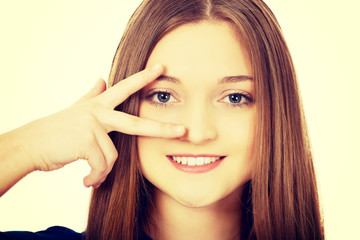 Happy teenager with victory sign on eye.