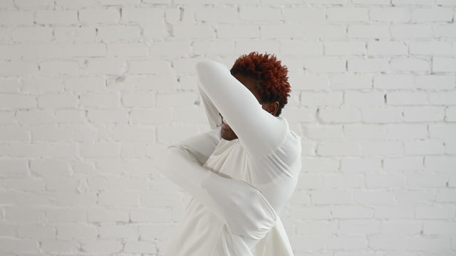 An insane black man in his forties wearing a straitjacket dance and try to get out