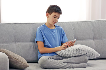 Boy using his mobile phone at home