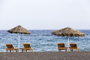 view of Perissa beach on the Greek island of Santorini with sunb