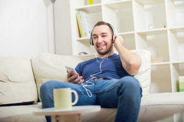Smiling young man in headphones at home