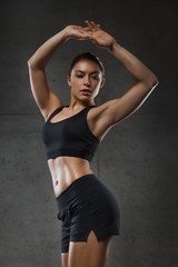 Fototapeta na wymiar young woman posing and showing muscles in gym