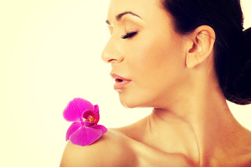 Woman with purple orchid petal on shoulder