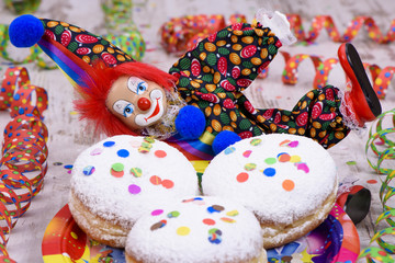 Fototapeta na wymiar Faschingskrapfen zu Karneval mit Luftschlangen und Clown