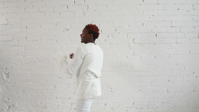 An insane black man in his forties wearing a straitjacket dance and have fun